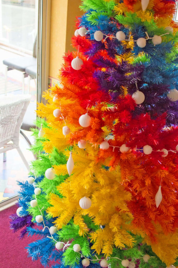Vibrant Rainbow Christmas Tree Wallpaper with White Ornaments