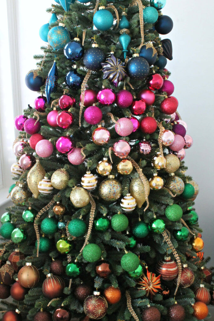 Vibrant Christmas Tree with Colorful Ornaments Against Neutral Background Wallpaper