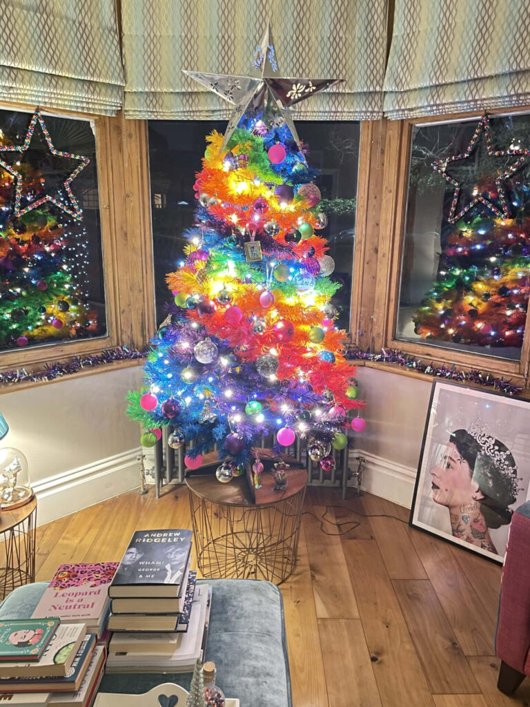 Cozy Corner Christmas: Vibrant Tree with Colorful Lights & Ornaments Wallpaper