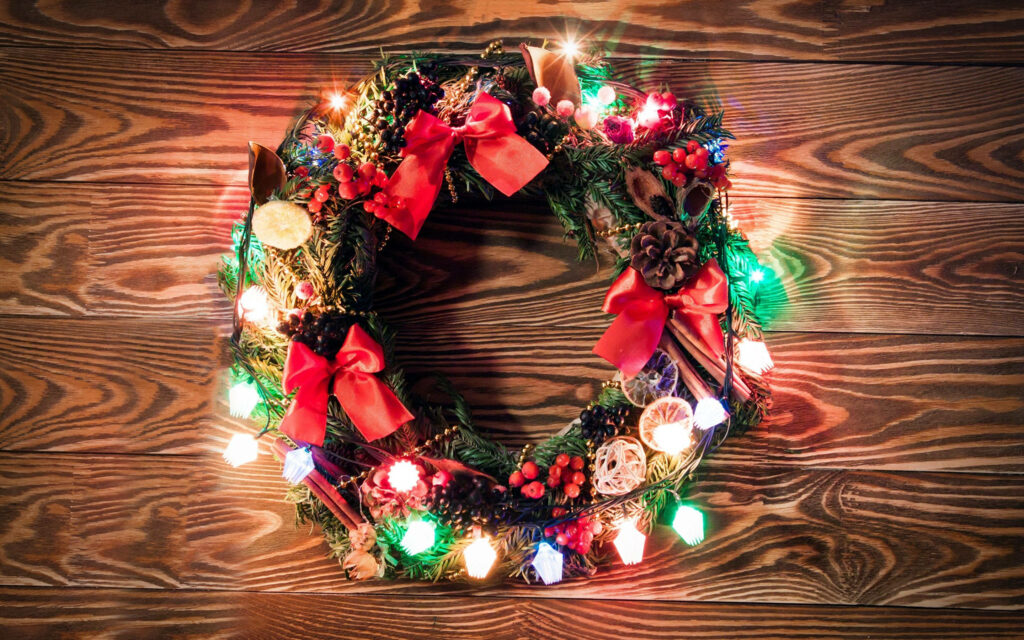 Vibrant Christmas Wreath Wallpaper with Lights & Cozy Wood Background