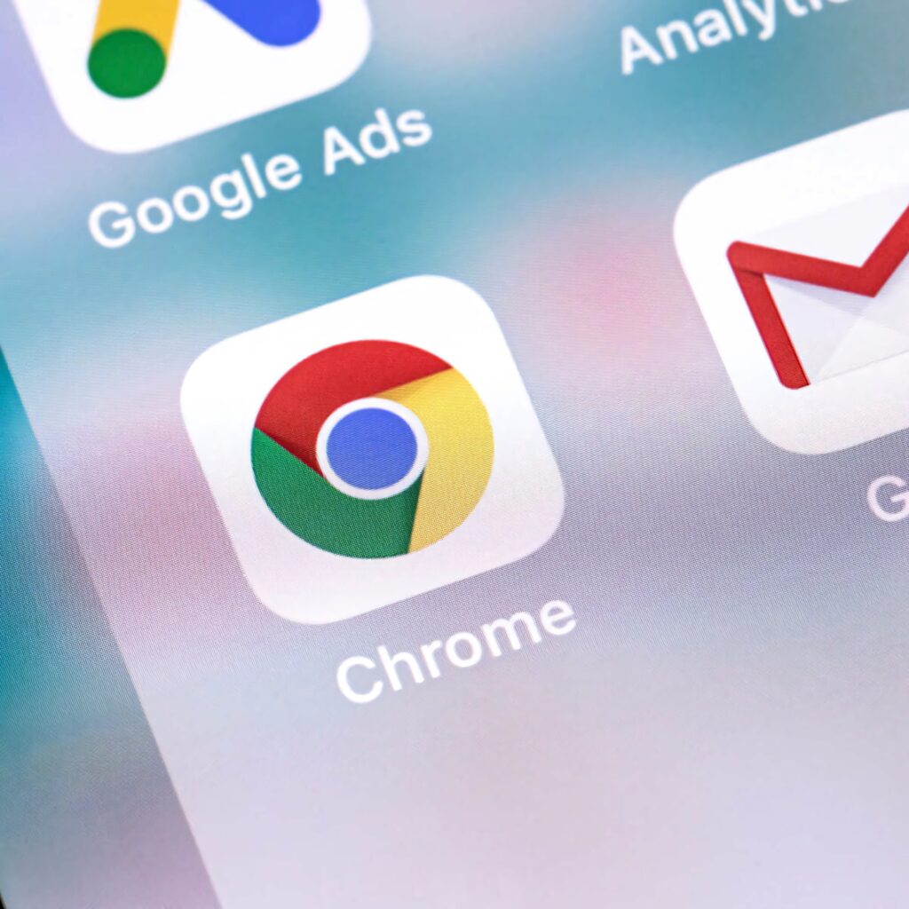 Close-up of vibrant Chrome app icon on smartphone screen with blurred digital background wallpaper