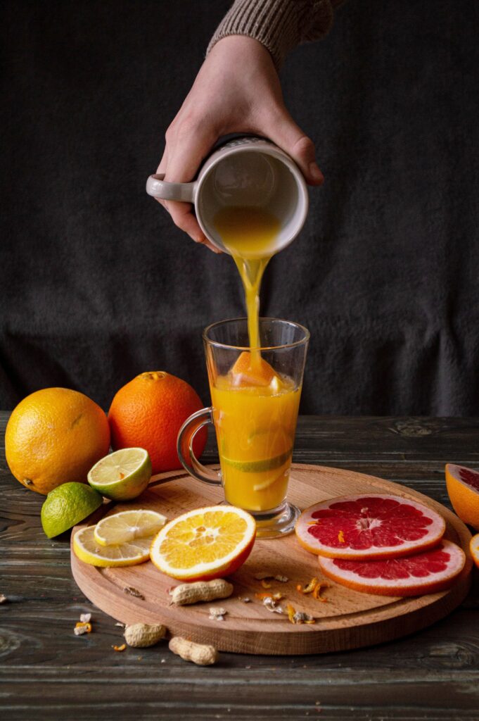 Vibrant Citrus Juice Wallpaper with Fresh Fruits on Wooden Platter