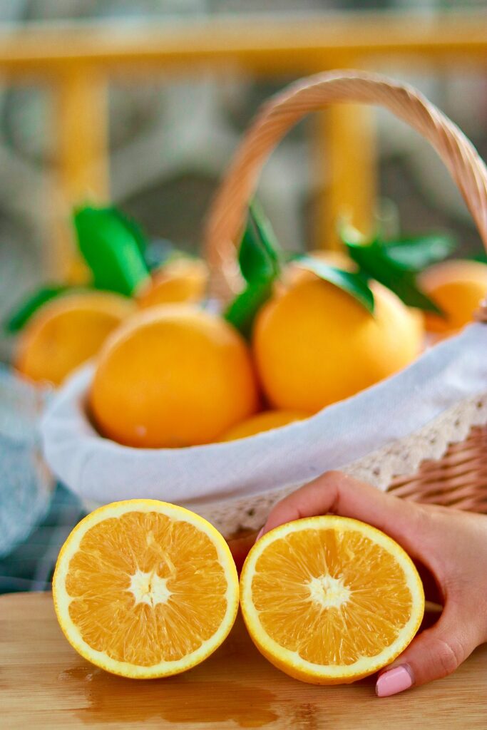 Fresh Citrus Wallpaper: Vibrant Oranges & Hand-Held Slice