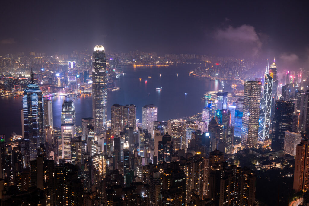 Vibrant City Nightscape Wallpaper: Skyscrapers & Sea Reflections