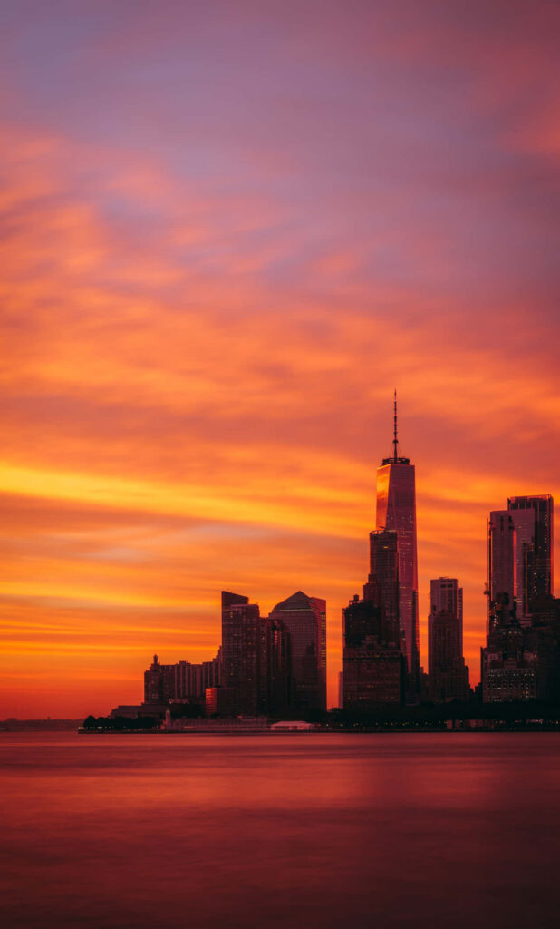 Vibrant City Sunset iPhone Wallpaper: Orange & Purple Gradient