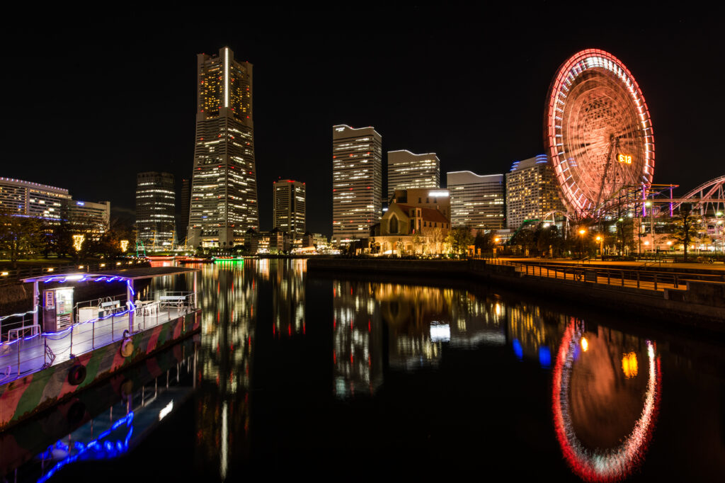 Vibrant Night Cityscape Wallpaper with Ferris Wheel Reflection