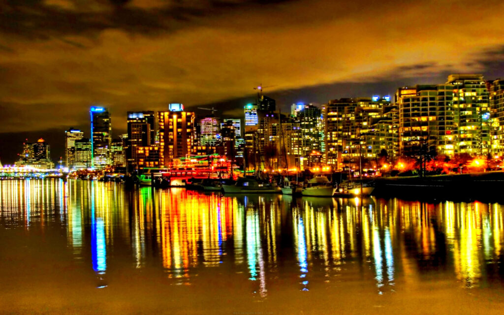 Vibrant Cityscape at Night: Reflective Water Wallpaper Background