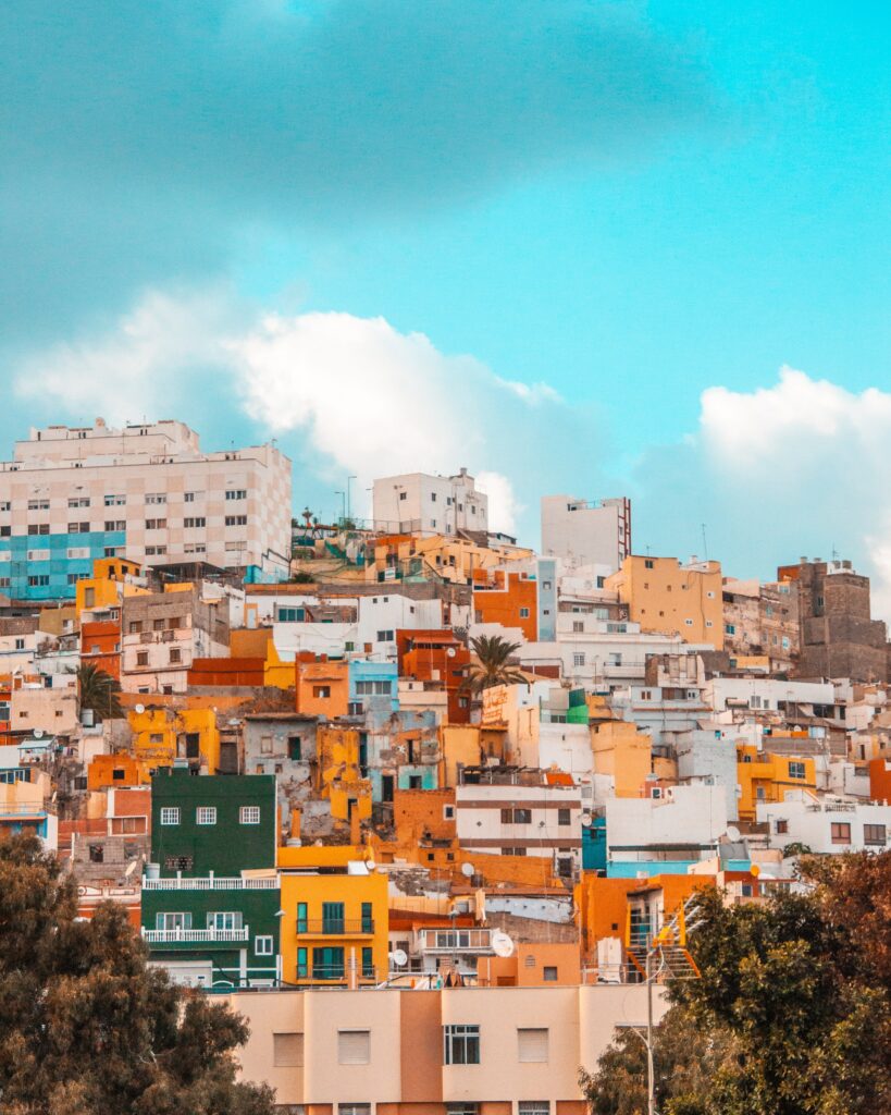 Vibrant Cityscape Wallpaper: Colorful Houses on a Green Hillside