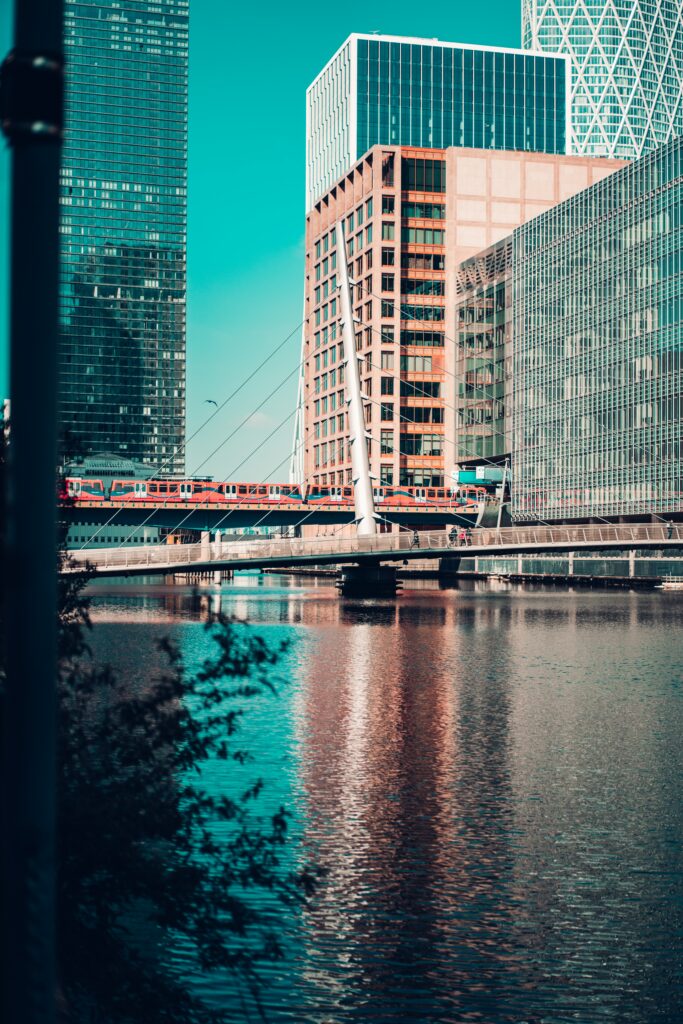 Vibrant Cityscape Wallpaper: Modern Buildings & Train Over River