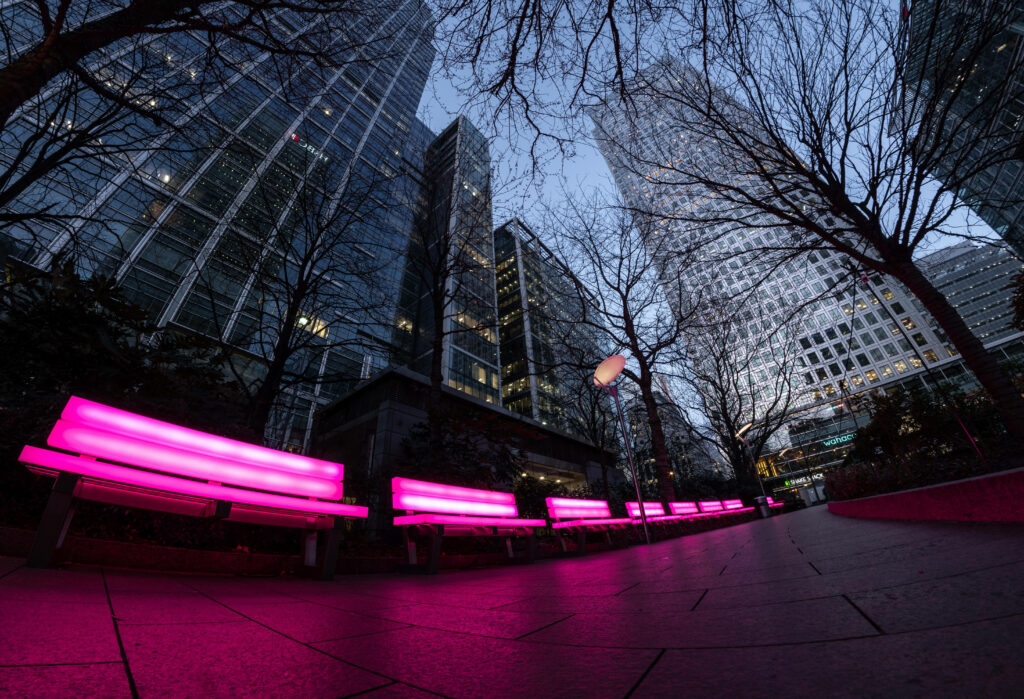 Futuristic Cityscape Wallpaper: Neon Pink Benches & Towering Buildings