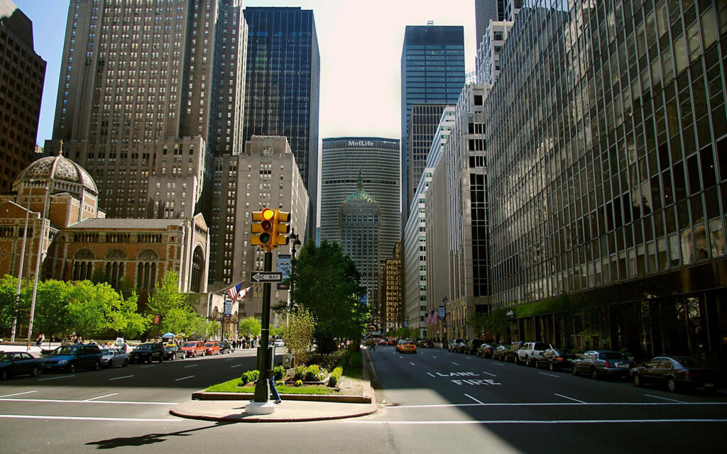 Vibrant Cityscape Wallpaper: Skyscrapers & Lush Greenery Under Daylight