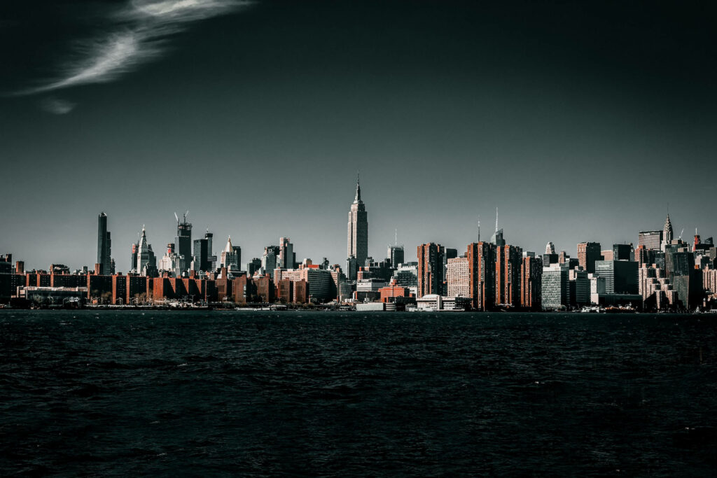 Vibrant Cityscape Wallpaper: Towering Buildings & Dark Waterfront
