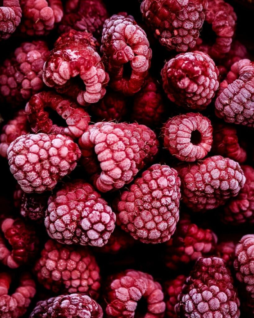 Vibrant Frozen Raspberries: Textured Red Berry Wallpaper Background