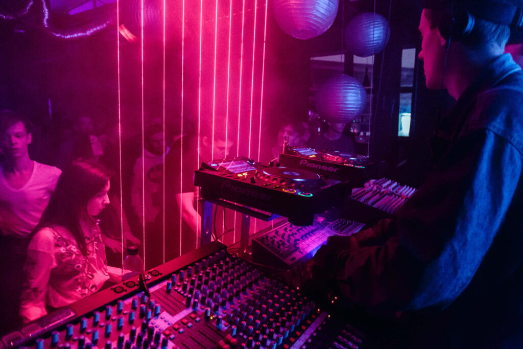 Vibrant Neon DJ Booth Wallpaper: Energetic Club Scene Background
