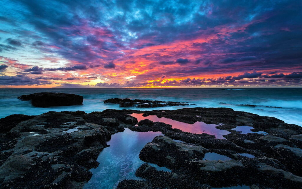 Vibrant Mirage of a Coastal Sunset: A Mesmerizing HD Wallpaper for Beach Lovers