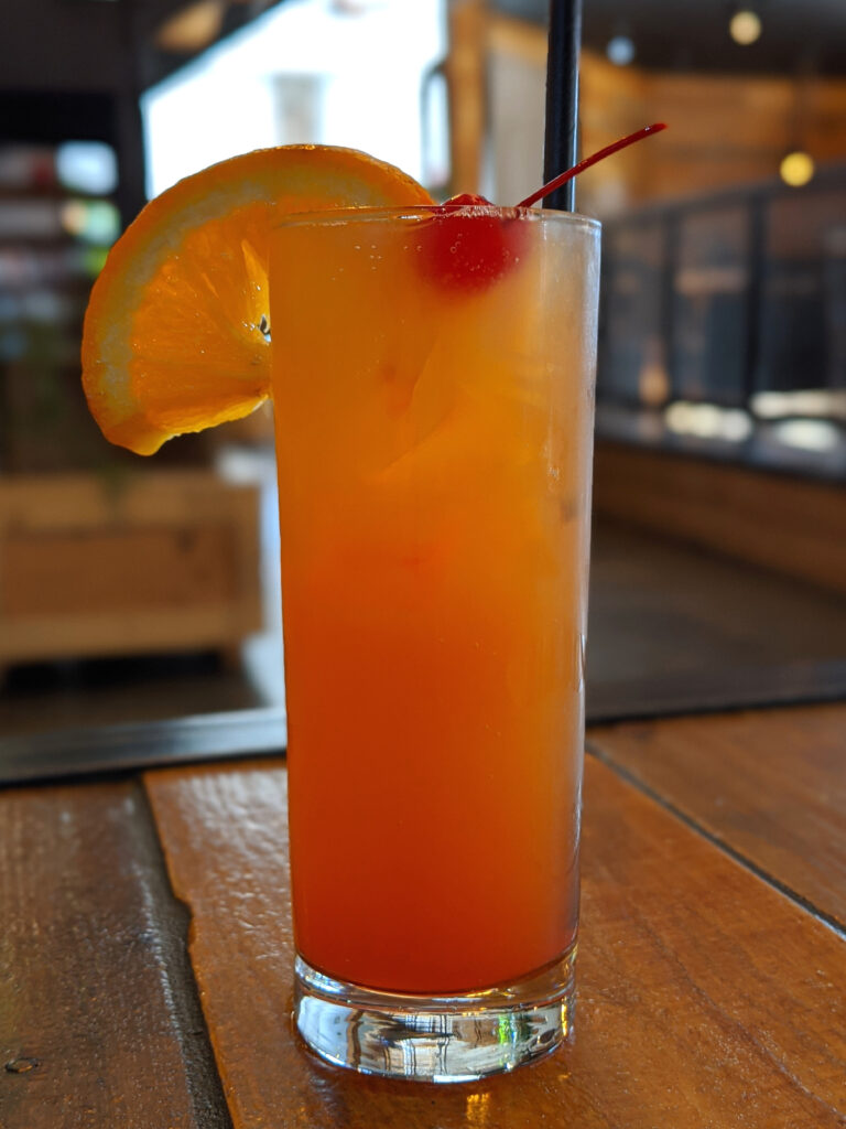 Vibrant Cocktail Wallpaper: Tall Glass with Orange Slice & Cherry