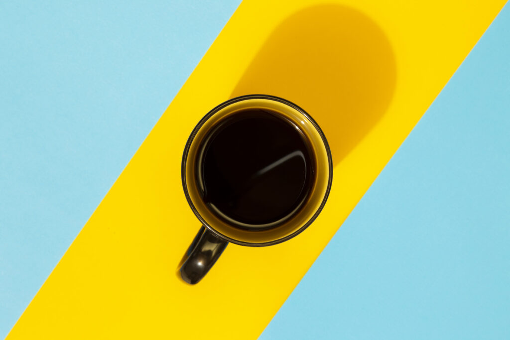Vibrant Wallpaper: Black Coffee Mug on Bold Blue-Yellow Stripes