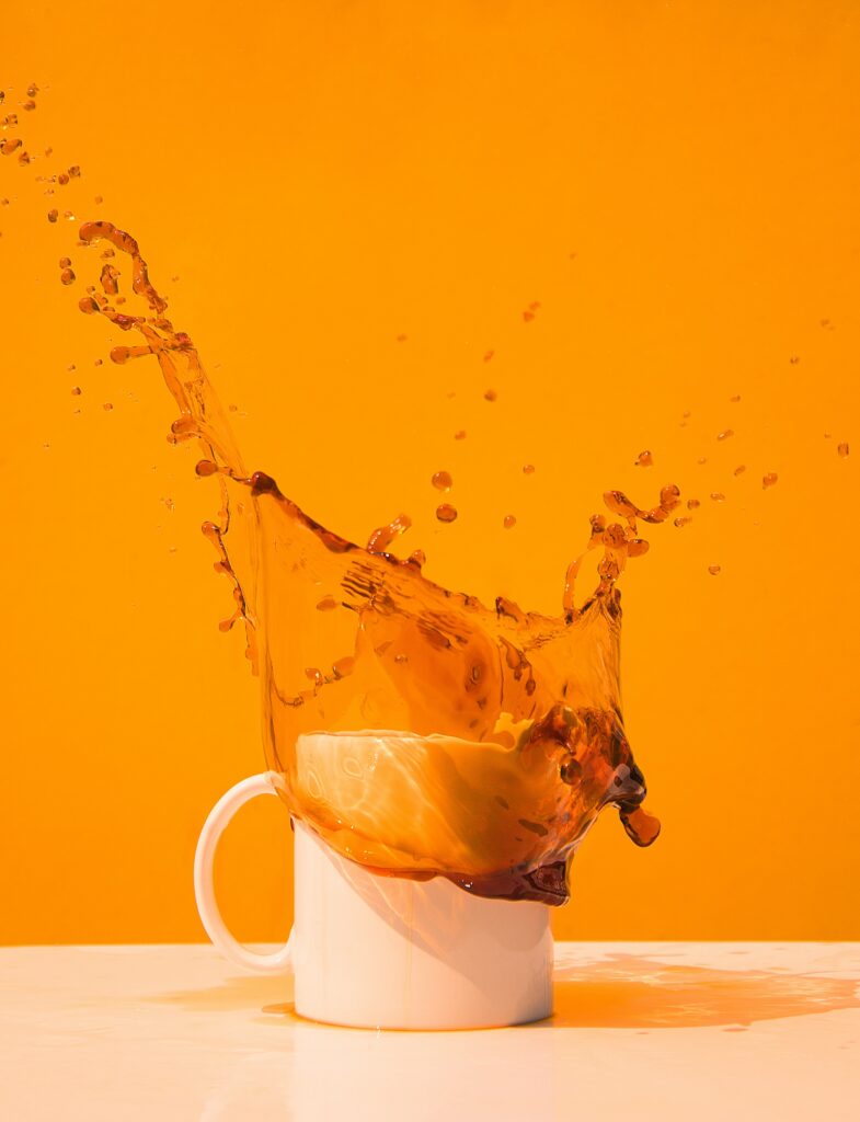 Dynamic Coffee Splash Wallpaper: Orange Background with Bold Energy