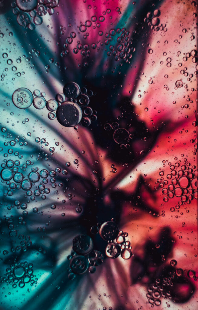 Vibrant 4K macro wallpaper of bubbles in electric teal and deep magenta fluid background