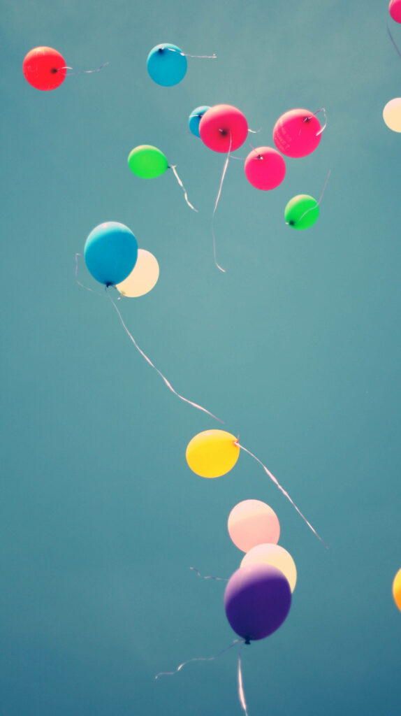 Colorful balloons floating against deep blue sky cheerful uplifting wallpaper background image