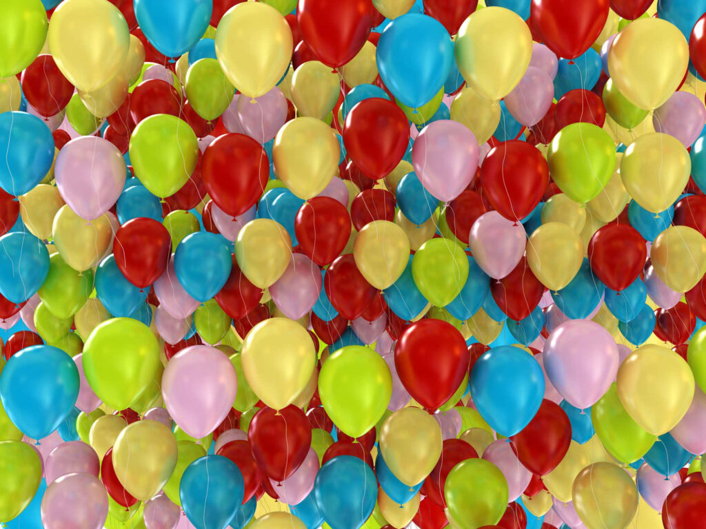 Hundreds of colorful balloons ascending into a bright sky creating a joyful dreamy scene wallpaper