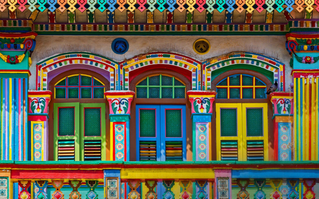 Colorful building facade with intricate arches windows vibrant artistic architectural wallpaper background