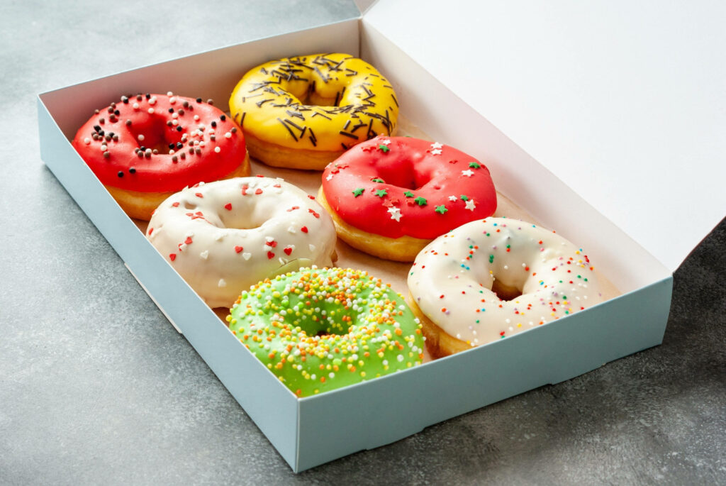 Close-up of six colorful donuts with glossy icing and sprinkles vibrant wallpaper background