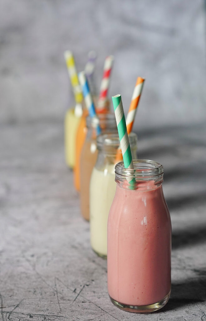 Colorful Milkshake Wallpaper: Vibrant Bottles with Striped Straws