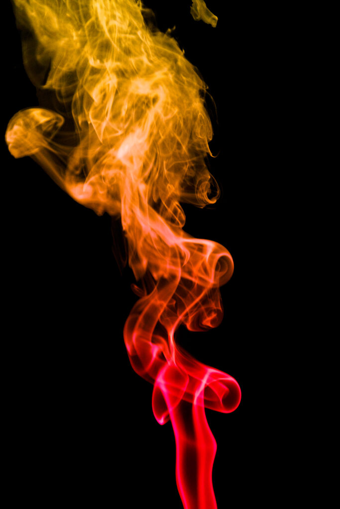 Vibrant Smoke Wallpaper: Bold Yellow & Red Swirls on Black Background