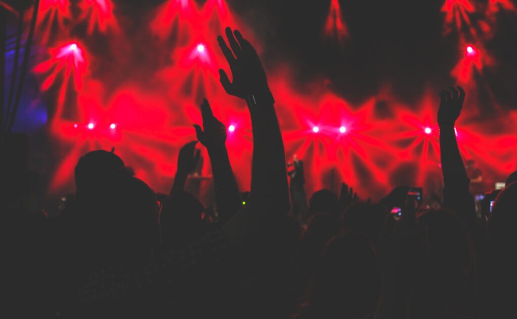 Vibrant Concert Wallpaper: Silhouettes & Red-lit Energy Background