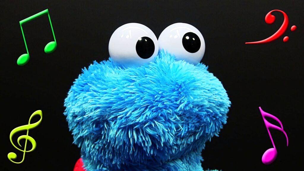 Cookie Monster with googly eyes on black background colorful musical notes vibrant wallpaper