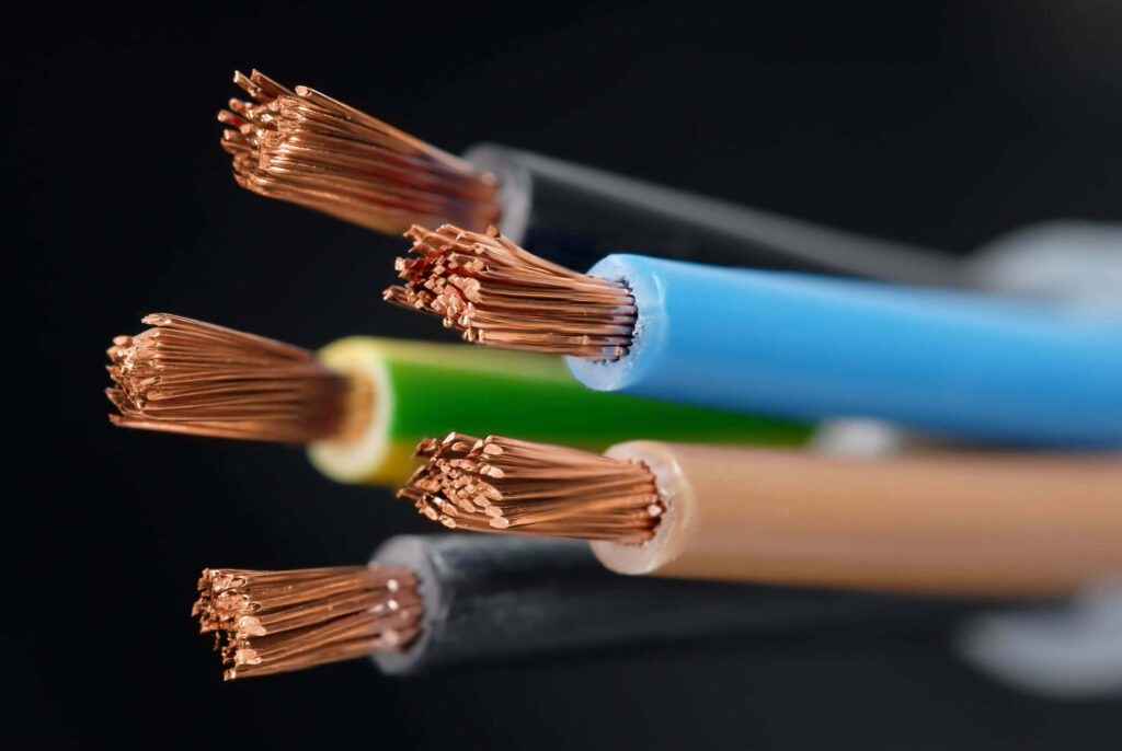 Close up of colorful insulated copper wires showcasing detailed strands and industrial precision Wallpaper