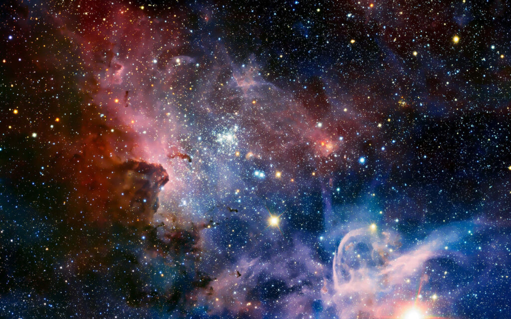 Vibrant cosmic wallpaper featuring colorful nebulae and sparkling stars in outer space.