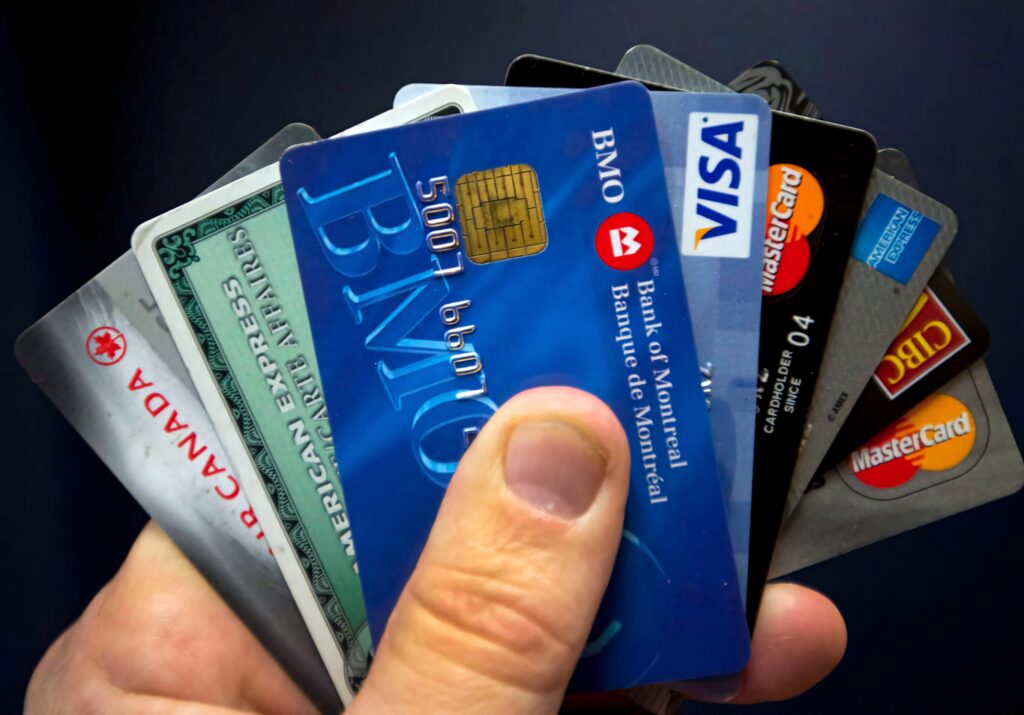 Hand holding colorful credit cards Visa Mastercard American Express modern financial lifestyle close-up Wallpaper