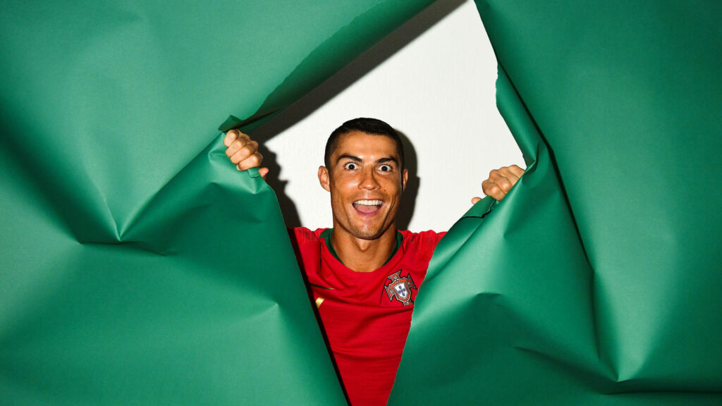 Vibrant Cristiano Ronaldo Wallpaper: Playful Peek Through Green Paper