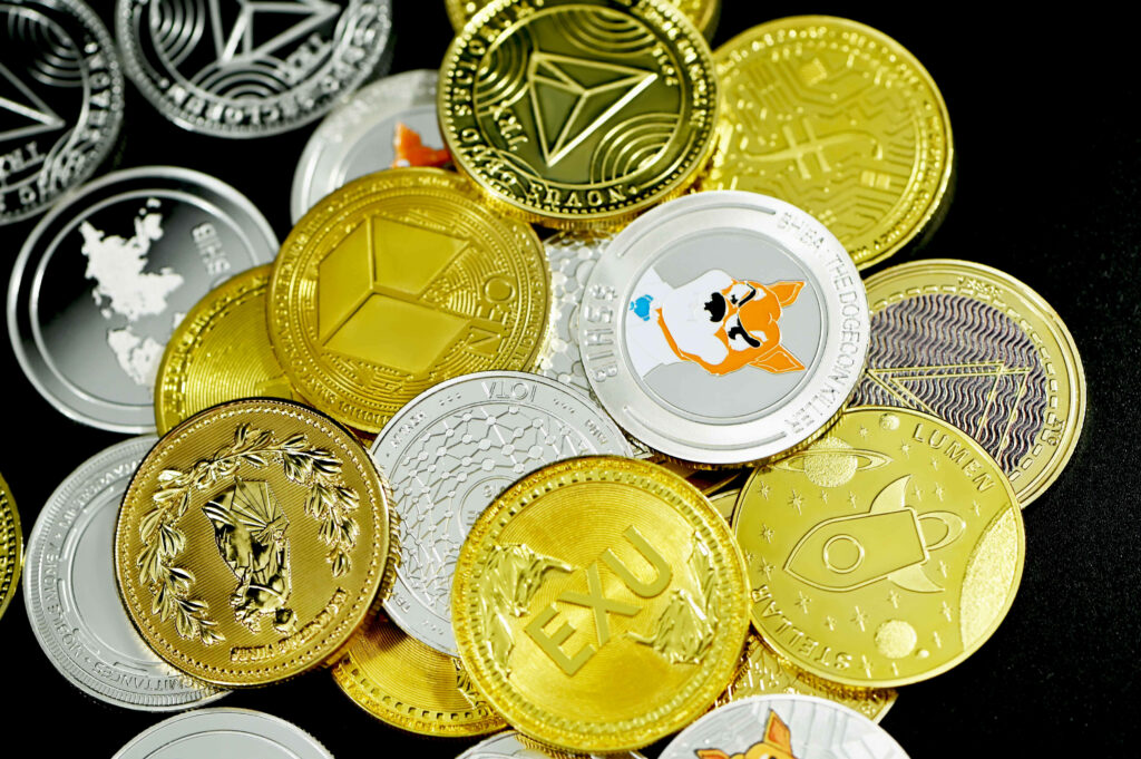 Vibrant cryptocurrency coins pile with detailed engravings and logos on dark background wallpaper