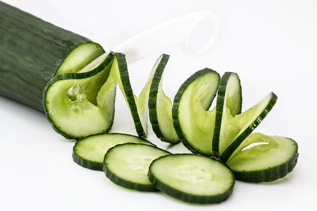 Vibrant Cucumber Wallpaper: Neatly Sliced Swirls on White Background