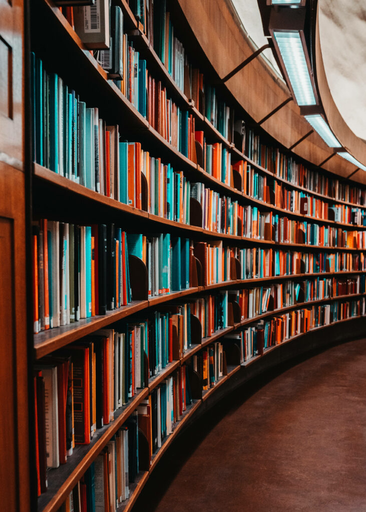 Curved bookshelf filled with colorful books in a modern library with tranquil inviting atmosphere Wallpaper