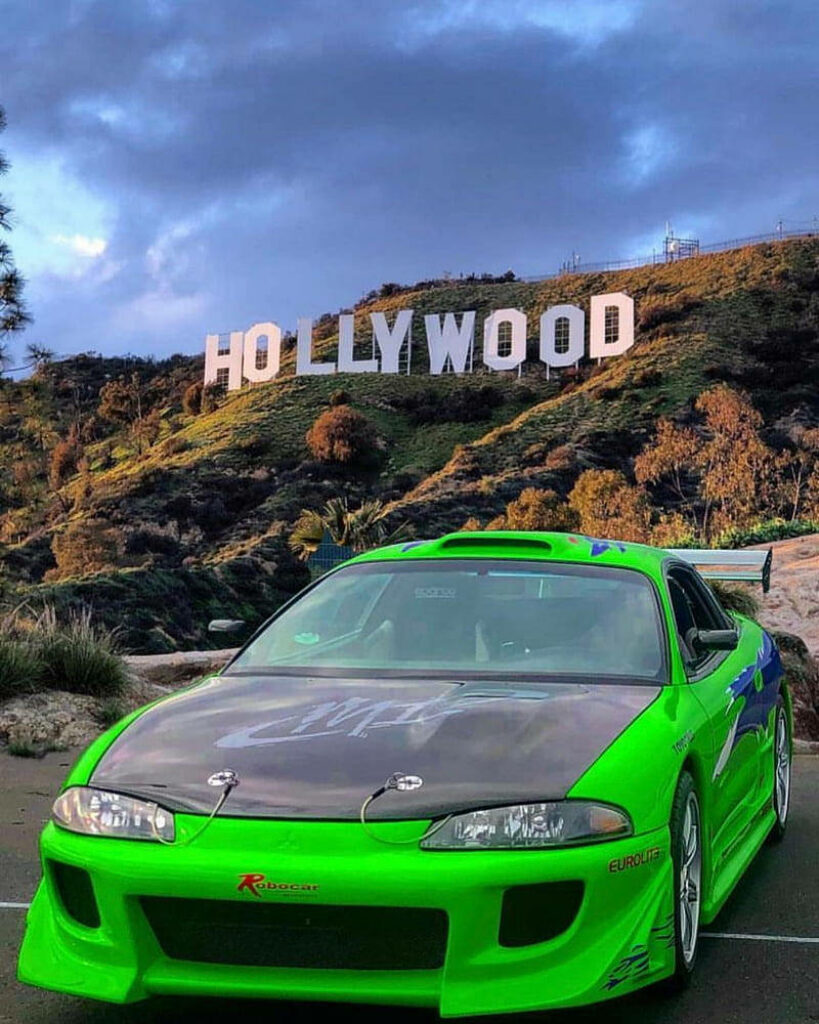 Vibrant Green Car Wallpaper: Urban Culture Meets Scenic Hollywood