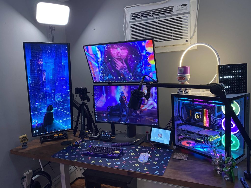 Vibrant gaming room with RGB Lian Li PC dual monitors cyberpunk wallpaper mechanical keyboard