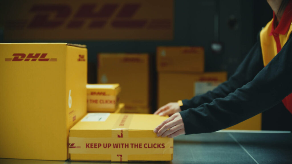 Vibrant wallpaper of yellow DHL boxes in modern warehouse showcasing global logistics and delivery