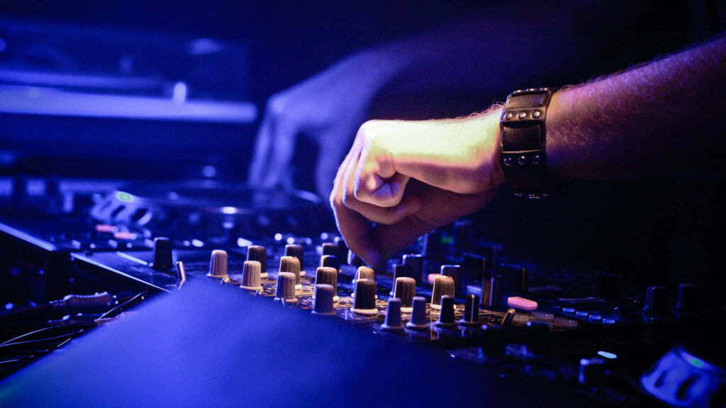 Vibrant DJ Wallpaper: Skillful Mixing in Dynamic Lighting