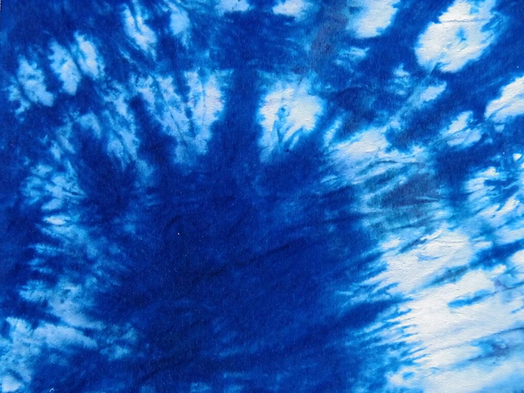 Vibrant deep blue and white tie-dye wallpaper with organic flowing patterns and rich texture
