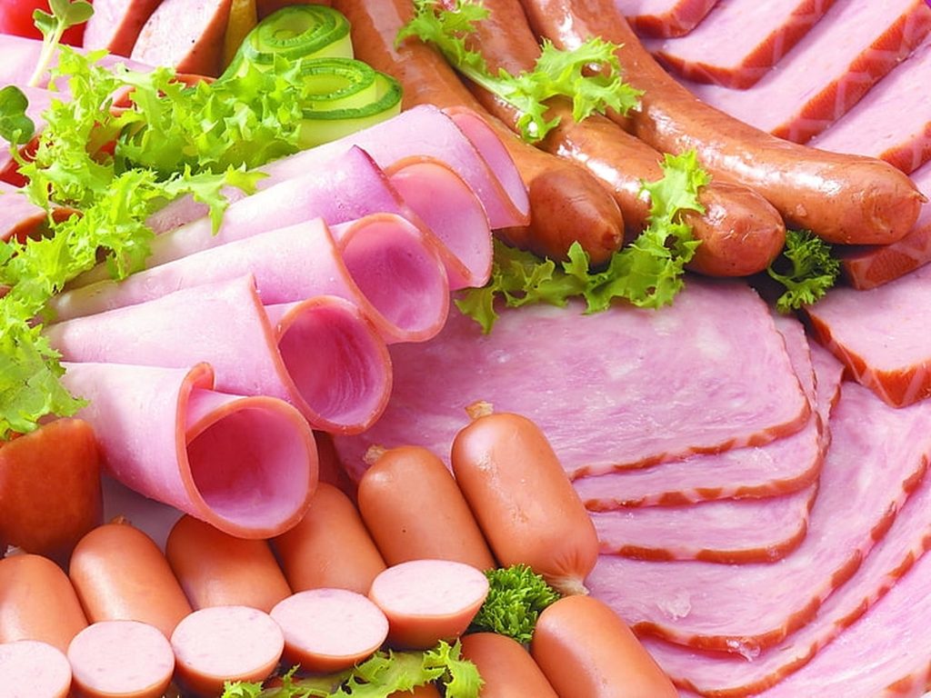 Assorted deli meats with rolled ham sausages frankfurters fresh lettuce cucumber background Wallpaper