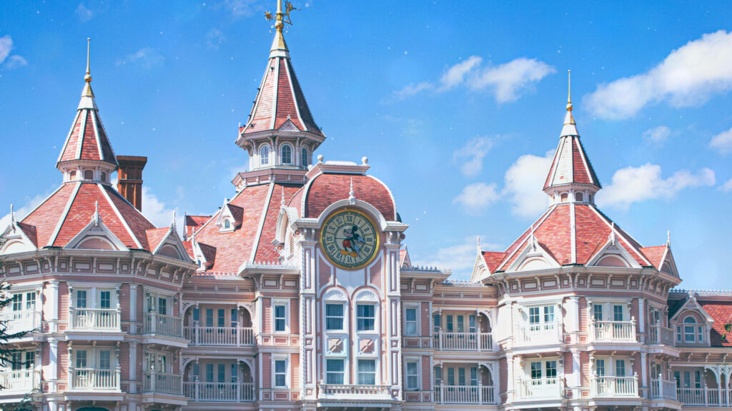 Vibrant Disneyland Clocktower wallpaper with red rooftops and bright blue sky background