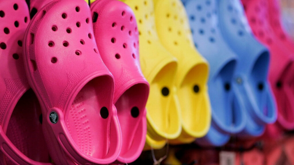 Footwear Fiesta: A Captivating Display of Colorful Crocs Delighting in the Background Wallpaper