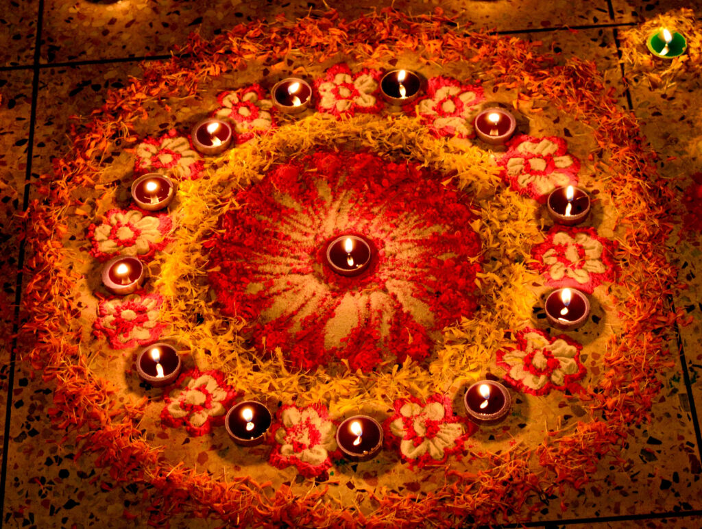 Vibrant Diwali wallpaper glowing diya candles in circle colorful floral rangoli festive lights