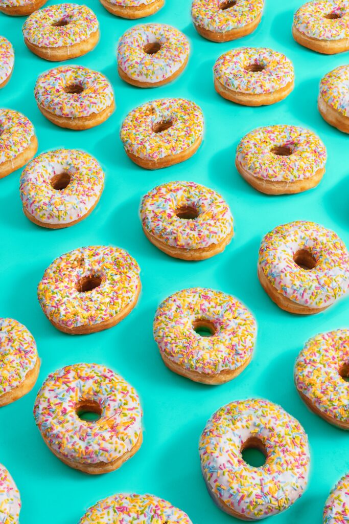 Vibrant Donuts with Sprinkles - Cheerful Turquoise Background Wallpaper