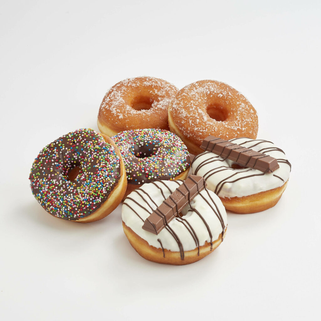 Vibrant donut wallpaper with colorful sprinkles powdered sugar chocolate and white icing topping