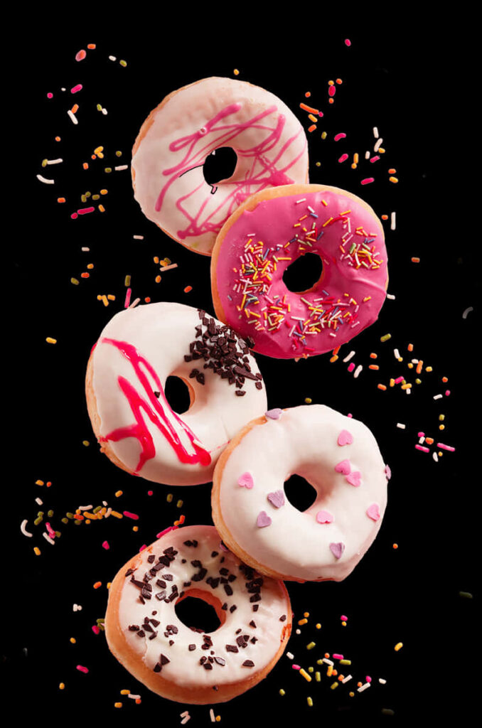 Colorful Donut Wallpaper: Assorted Treats Against Black Background